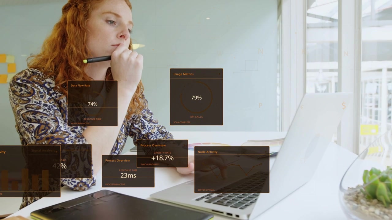 Woman working at desk by window, design panels rising, using pen and tapping laptop, checking data
