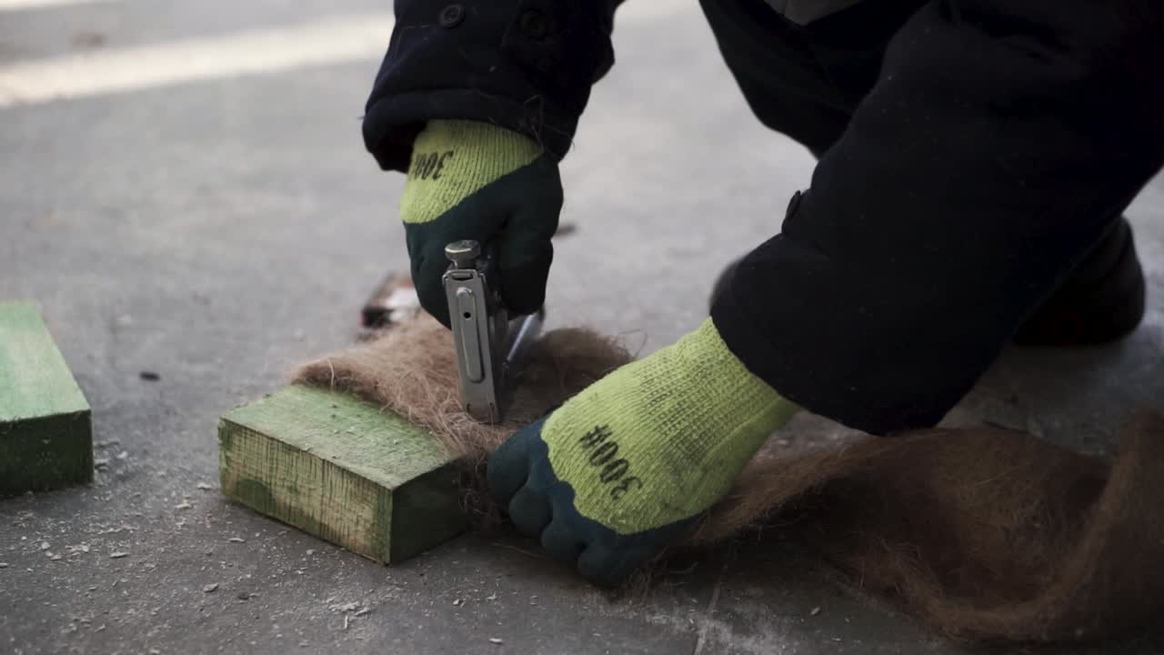 trabajador que instala aislamiento con grapadora