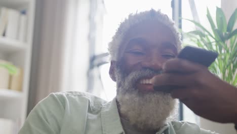 Video-of-african-american-senior-man-using-smartphone