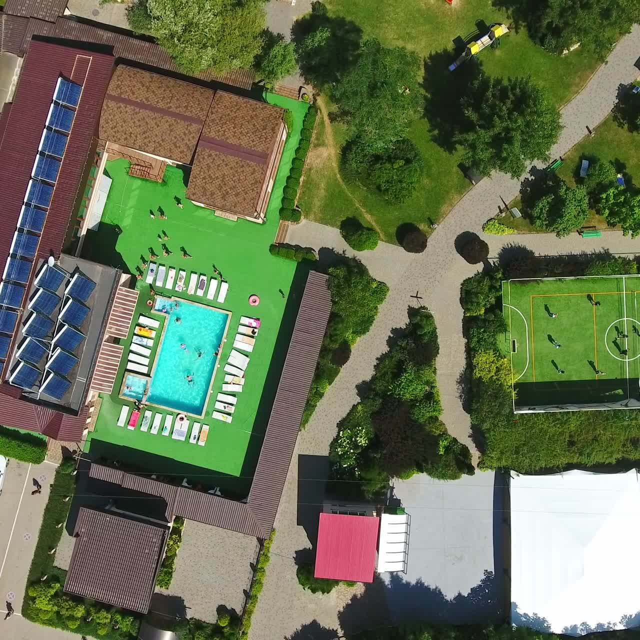 Countryside spa resort complex with diverse areas for rest. Swimming-pools, pond, tennis court and chaise-longues zone for comfortable time-spending. Aerial view