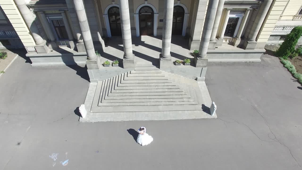 Wedding Day. Wedding Session. Aerial shot of a happy wedding couple hugs each other before old building