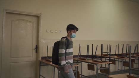 student walking into the empty classroom