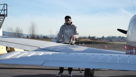 Piloto-Persa-Masculino-Alimenta-Avión-Monomotor-Ligero,-Día-Soleado-Slomo