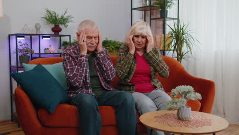 displeased senior old man woman having headache problem suffering from tension and migraine, stress