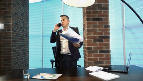 businessman throwing paper sheets in the air. businessman throwing paper sheets in the air and talking on the mobile phone