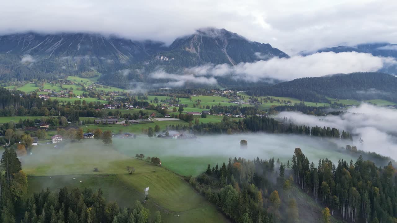 schladming austria - paisaje de valle natural con nubes y niebla matutina - 4k aéreo