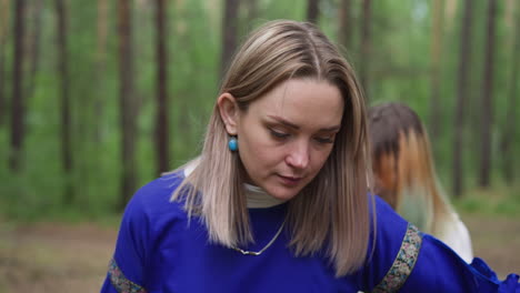 woman with students in middle age clothes walks through wood