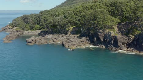 Kayak-trip-along-shore-of-beautiful-natural-island,-Moutohora,-aerial