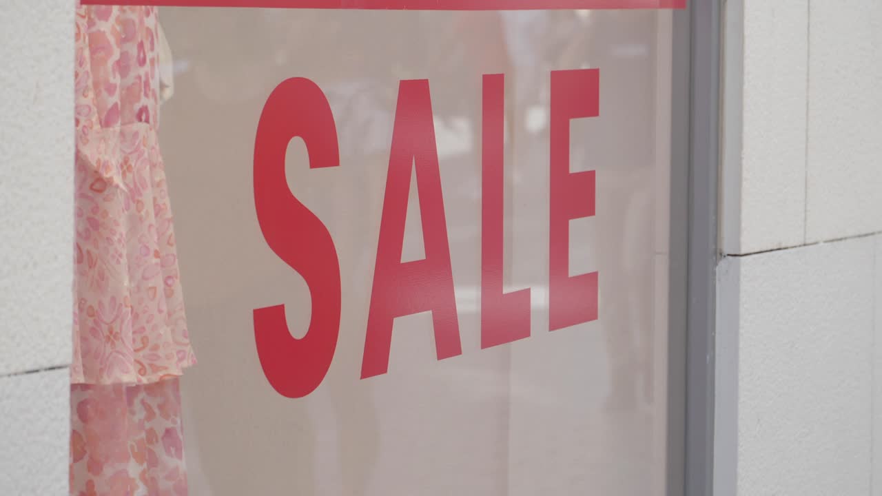 letrero de venta rojo en una ventana de una tienda