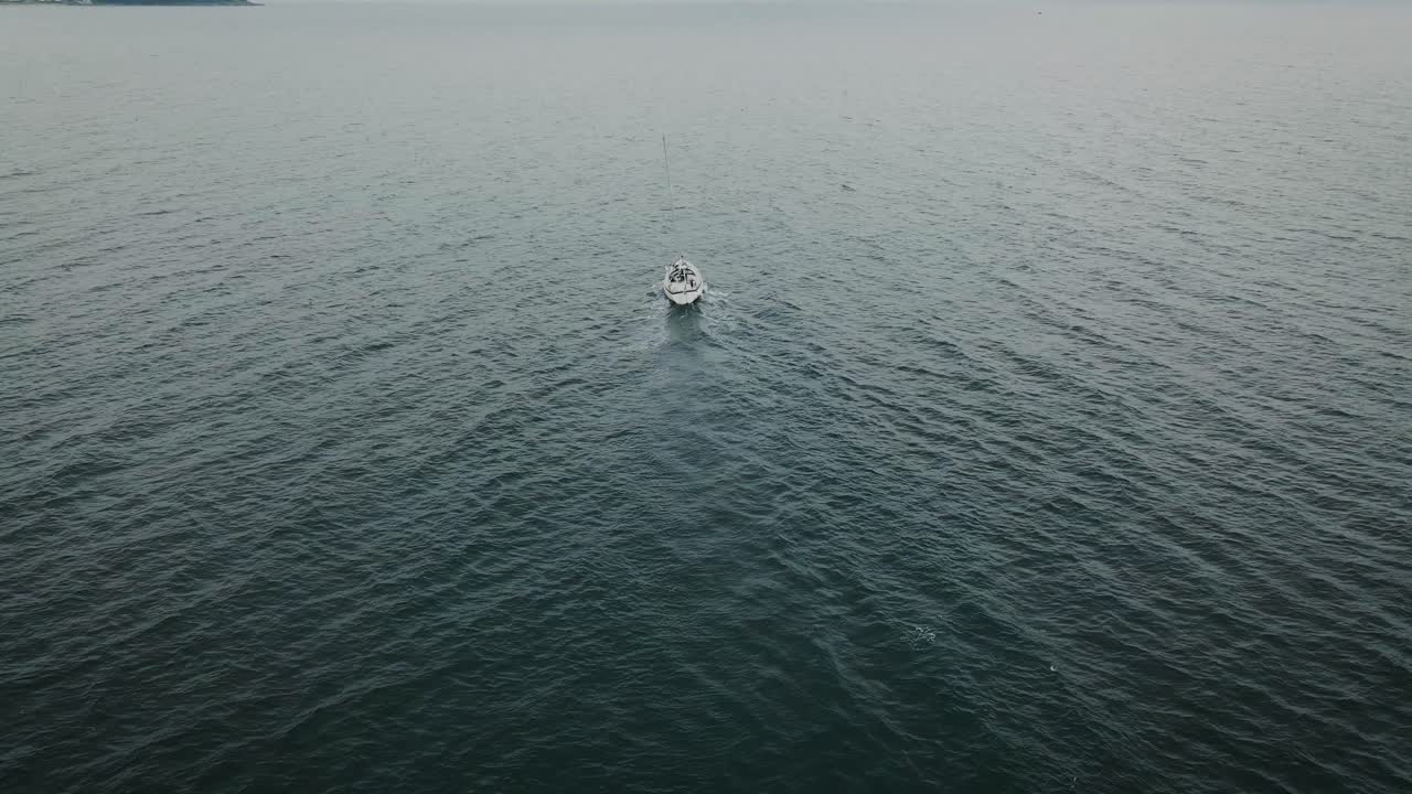 Ripresa aerea inclinata che segue una barca a vela in mare.