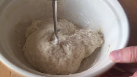 Making-bread-dough,-mixing-it-with-an-electric-mixer-in-a-ceramic-mixing-bowl