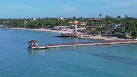 long pier and lighthouse bar on playa dominicus beach, bayahibe in dominican republic. aerial sideways