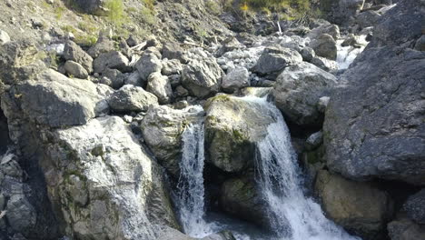 drone ascending and tilting down in front of a mountain stream in the austrian alps at fall