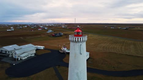 aerial orbit of the top of a tall lighthouse on a calm morning near the ocean