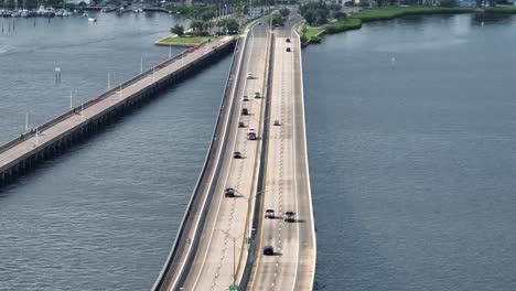 cars on bridge crossing manatee river and arriving bradenton town, florida. sunset evening in summer. palmetto fishing pier in usa