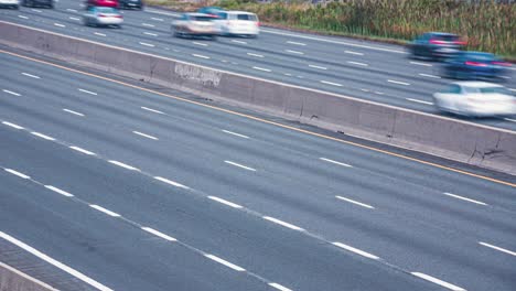 coches en movimiento rápido y camiones de transporte en la autopista. tráfico diurno en la ciudad. coches en movimiento rápida con borrón de movimiento, larga exposición. bucle de lapso de tiempo de 4k.