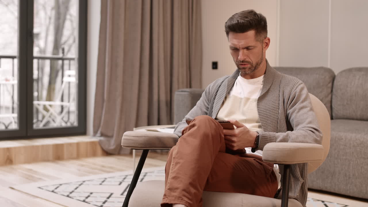 Man Sitting in Armchair with Tablet Computer