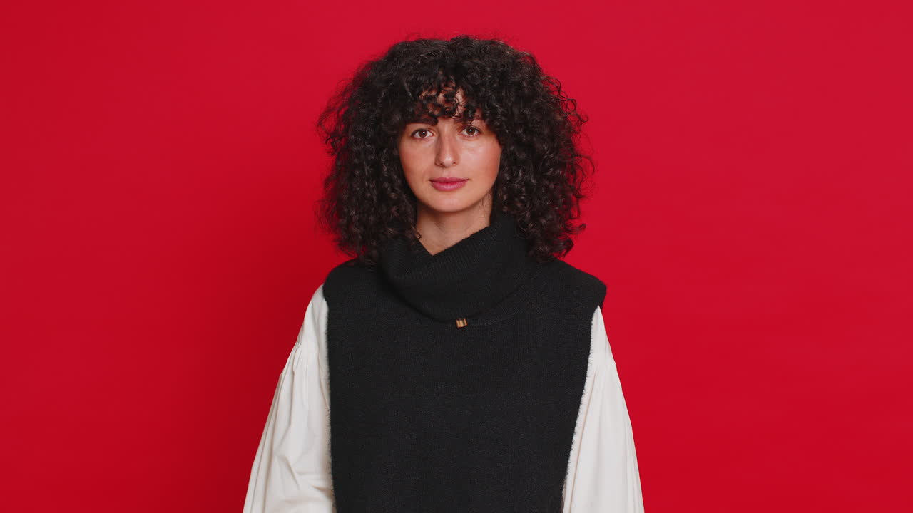 Young woman pointing at eyes and camera show i am watching you gesture spying watching on someone