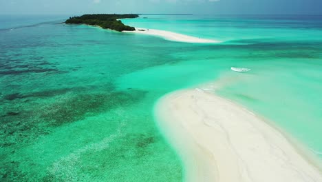 peaceful great turquoise lagoon with different coral patterns surrounding white sandy stripe and low-lying tropical island in fulhadhoo, maldives