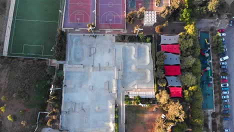aerial view of urban park with skatepark, playground, and basketball court