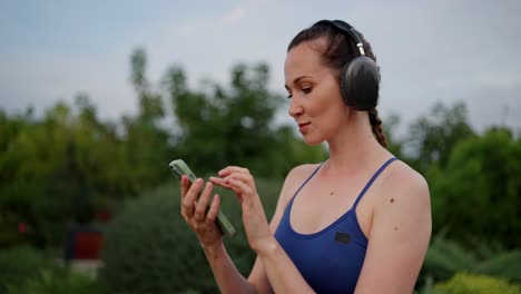 woman exercising outdoors with headphones and phone