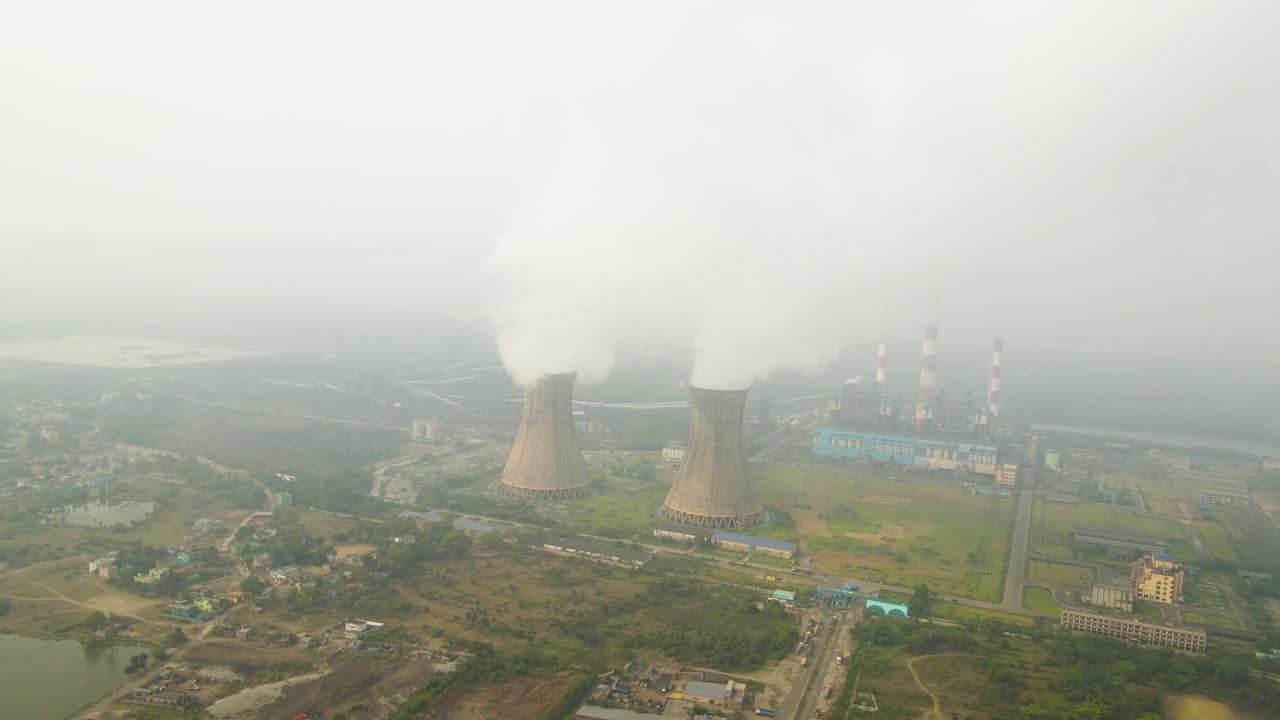 Aerial view of smoke-emitting factories in India, reflecting industrial growth and environmental impact.