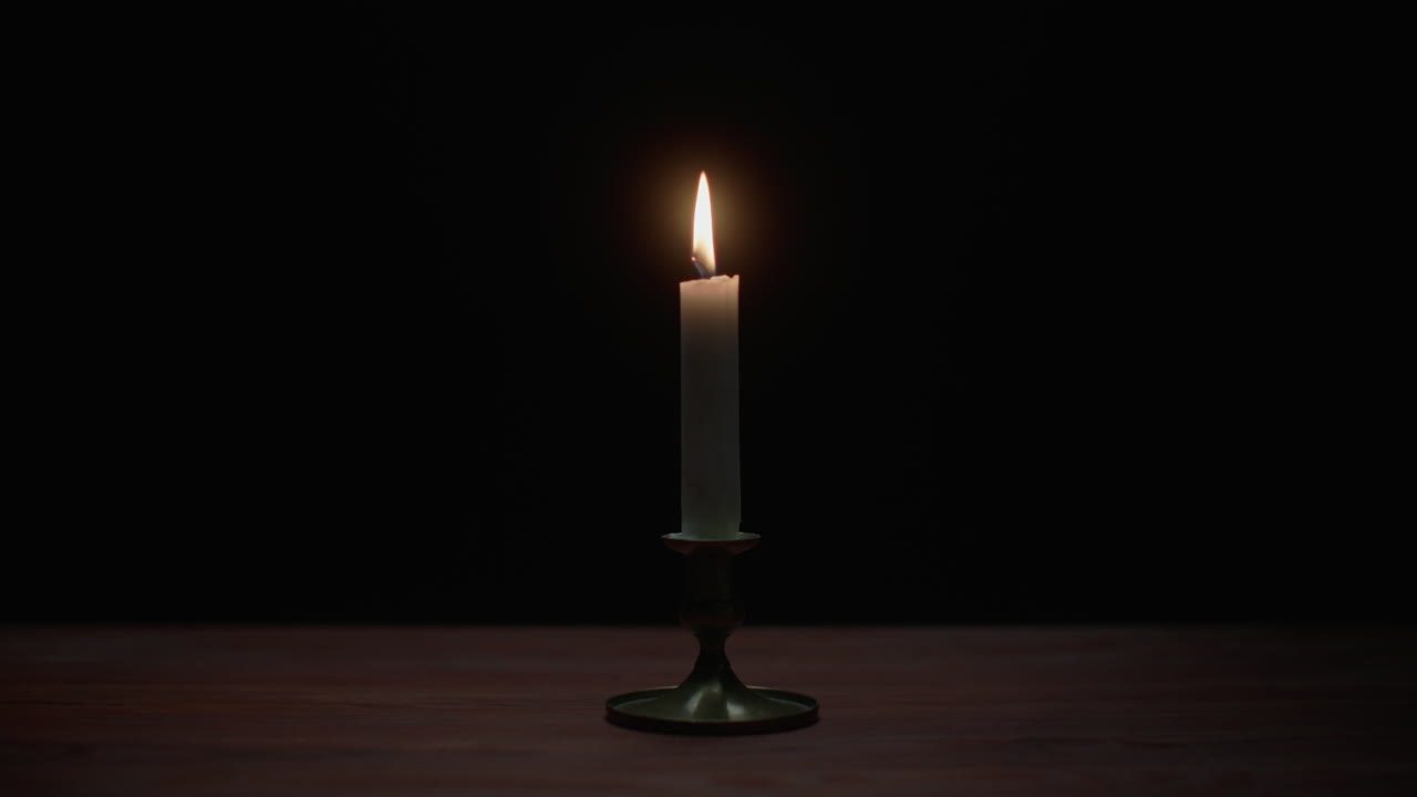 A candle burs out in the dark room