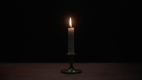 a candle burs out in the dark room