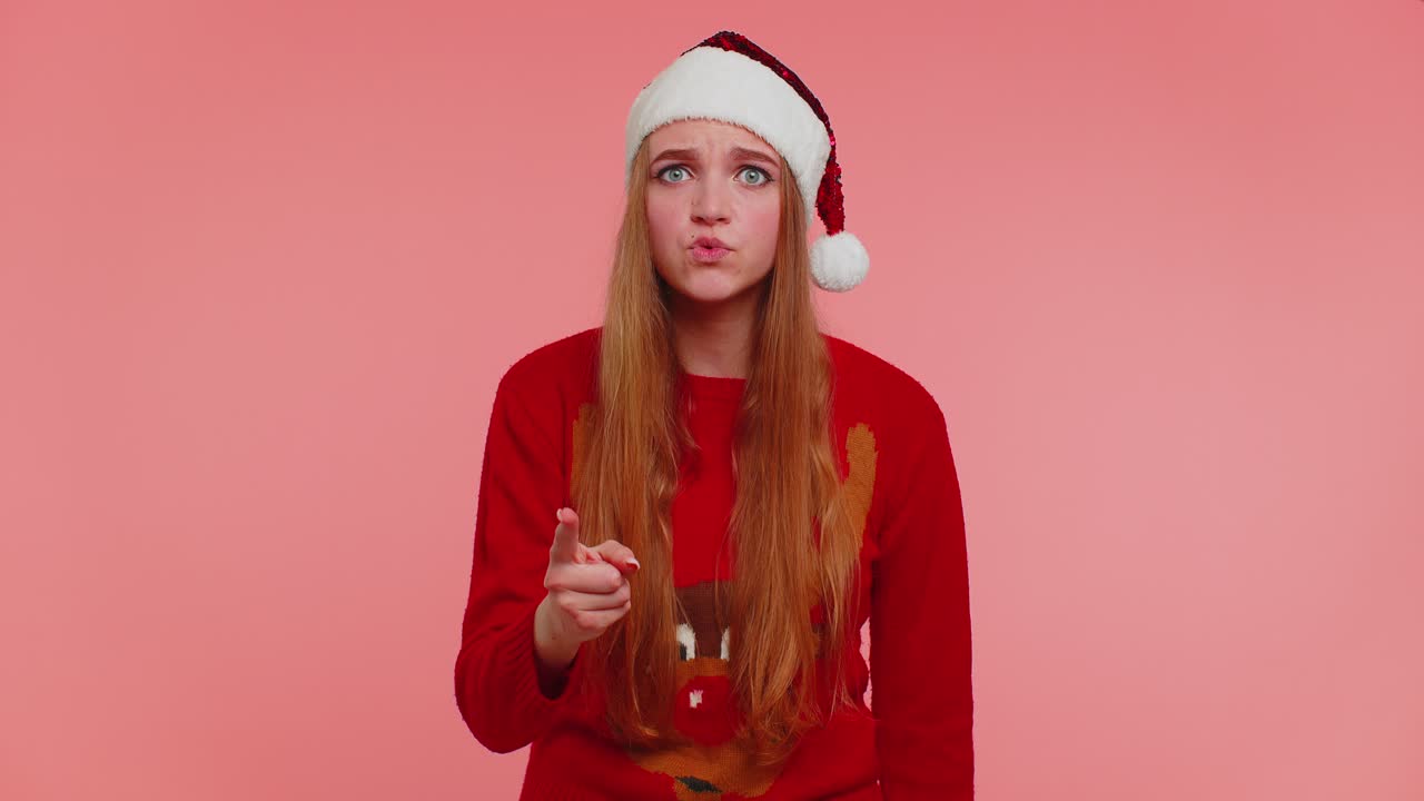 Displeased girl in christmas sweater gesturing hands with displeasure blaming scolding for failure