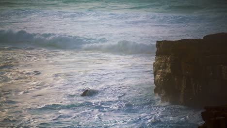 storming waves rolling cliff seashore. foamy ocean splashing washing rocky coast