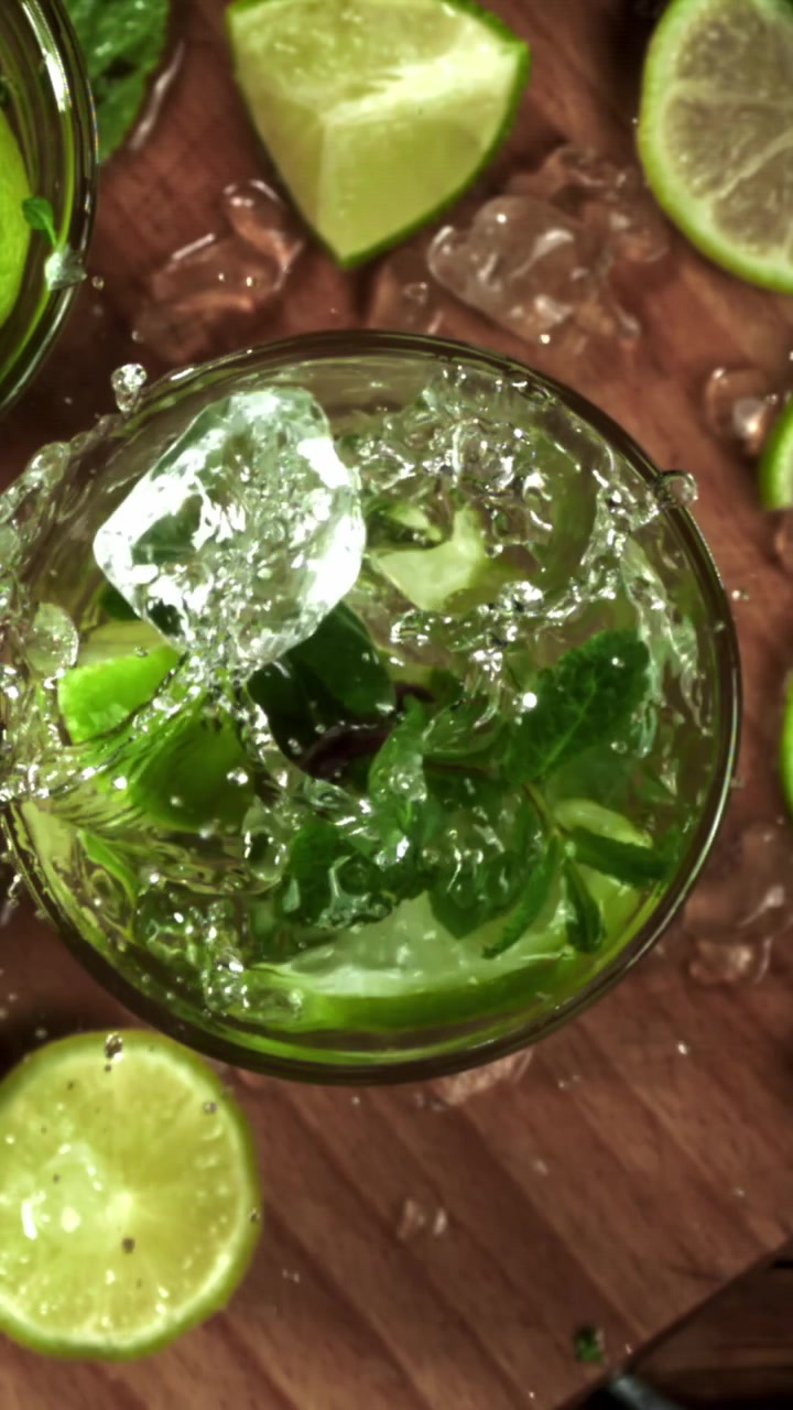 Hidastettu kuva jääpaloista roiskumassa raikkaaseen Mojito-cocktailiin