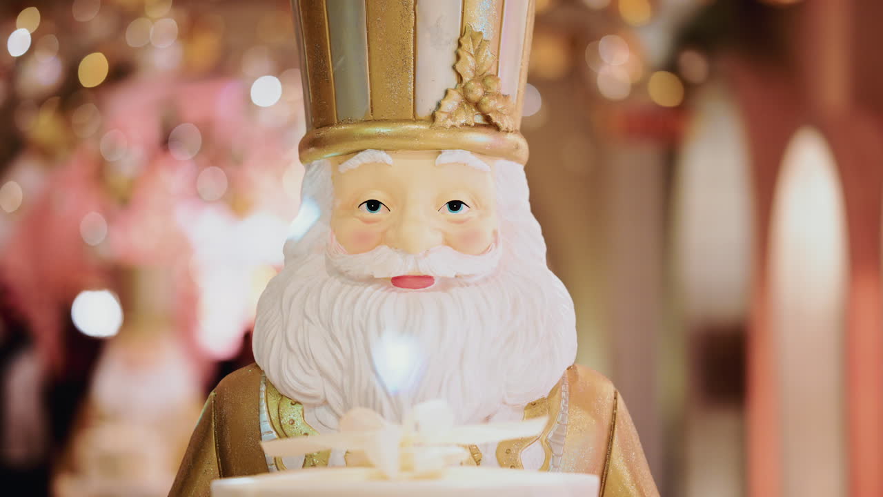 Close up of a Santa Claus figure inside a festive Christmas installation with warm lights and ornaments
