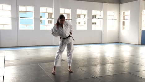 practicing judo, person in white gi standing on mat in dojo