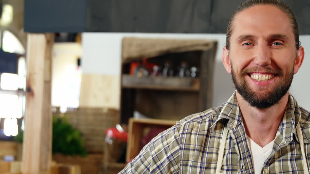 retrato de un personal masculino sonriente de pie en la sección de panadería