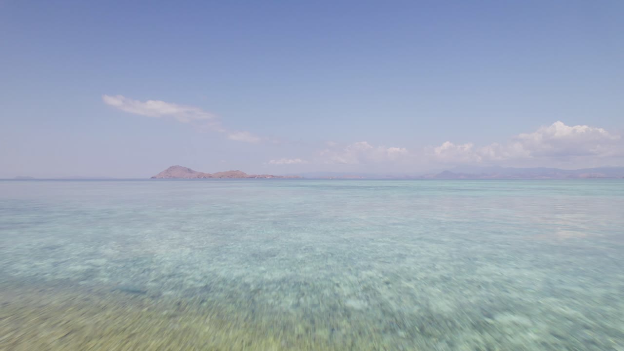 낮에 황량한 백사장 코모도 섬의 얕은 바닷물 위로 공중 비행