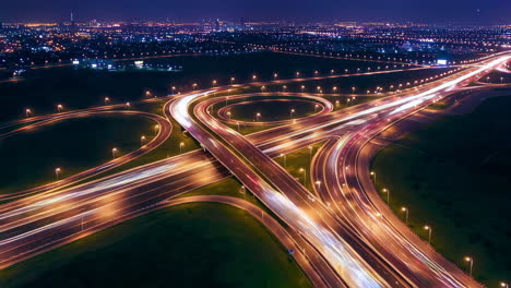 aerial view of a highway interchange at night with light trails