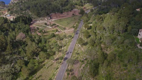 siguiente toma de una motocicleta conduciendo por un camino de montaña en la isla de mallorca, aero