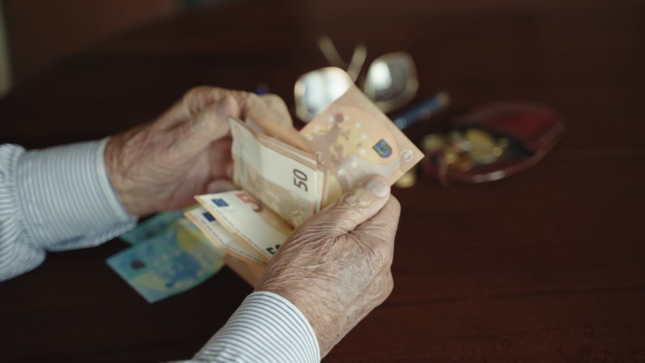 Male businessman in retirement holding business deals being general accountant, entrepreneur owner keeping accounts in office room, elderly businessman sitting at the desk table and counting money