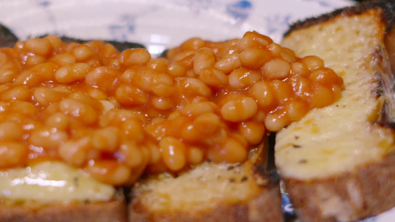 Overview of Baked Beans on Melted Cheese on Homemade Fresh Toast Served at Lunch for Quick Cheap Fibre Rich Meal 4K.
