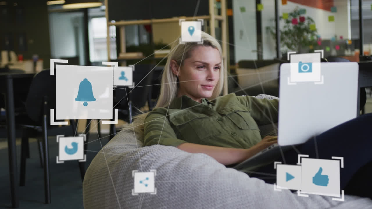 animación de iconos de los medios sobre una mujer de negocios caucásica que usa una computadora portátil