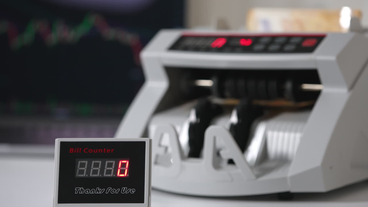 White compact money-counting machine working. Fifty euro banknotes calculated in the equipment. Close up. Blurred backdrop.
