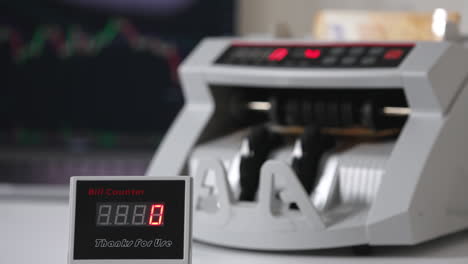 white compact money-counting machine working. fifty euro banknotes calculated in the equipment. close up. blurred backdrop.