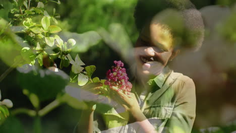 Animation-of-plants-over-african-american-woman-working-in-garden