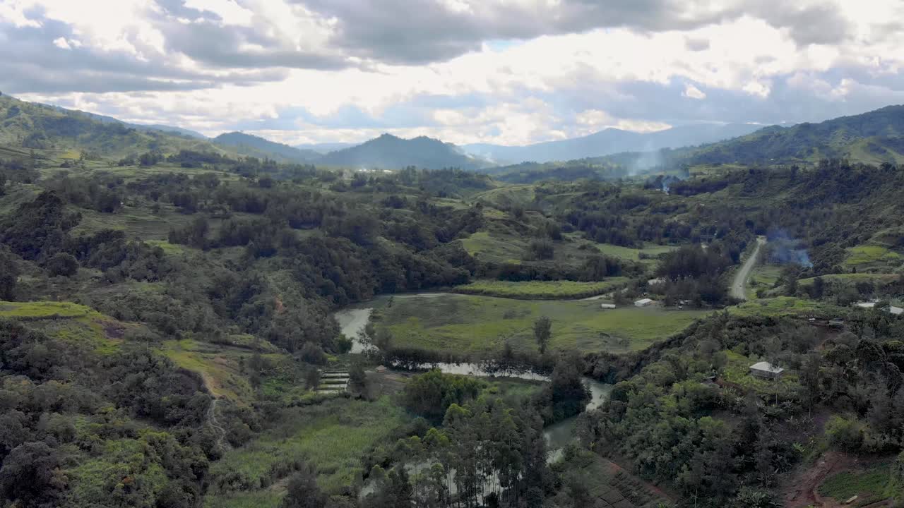 Green mountains landscape with river and road, Papua New Guinea aerial background