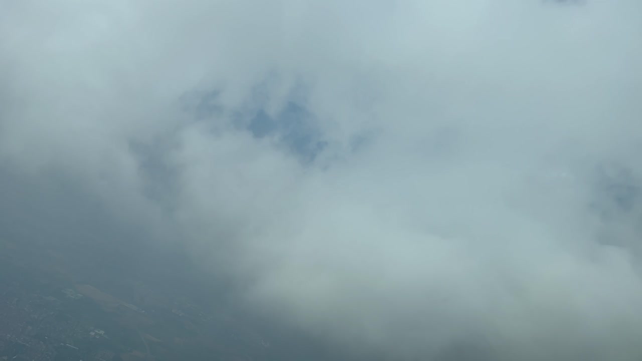 좌회전하여 공항으로 하강하는 동안 구름층을 뚫고 비행하는 동안 제트기 조종석에서 공중 보기