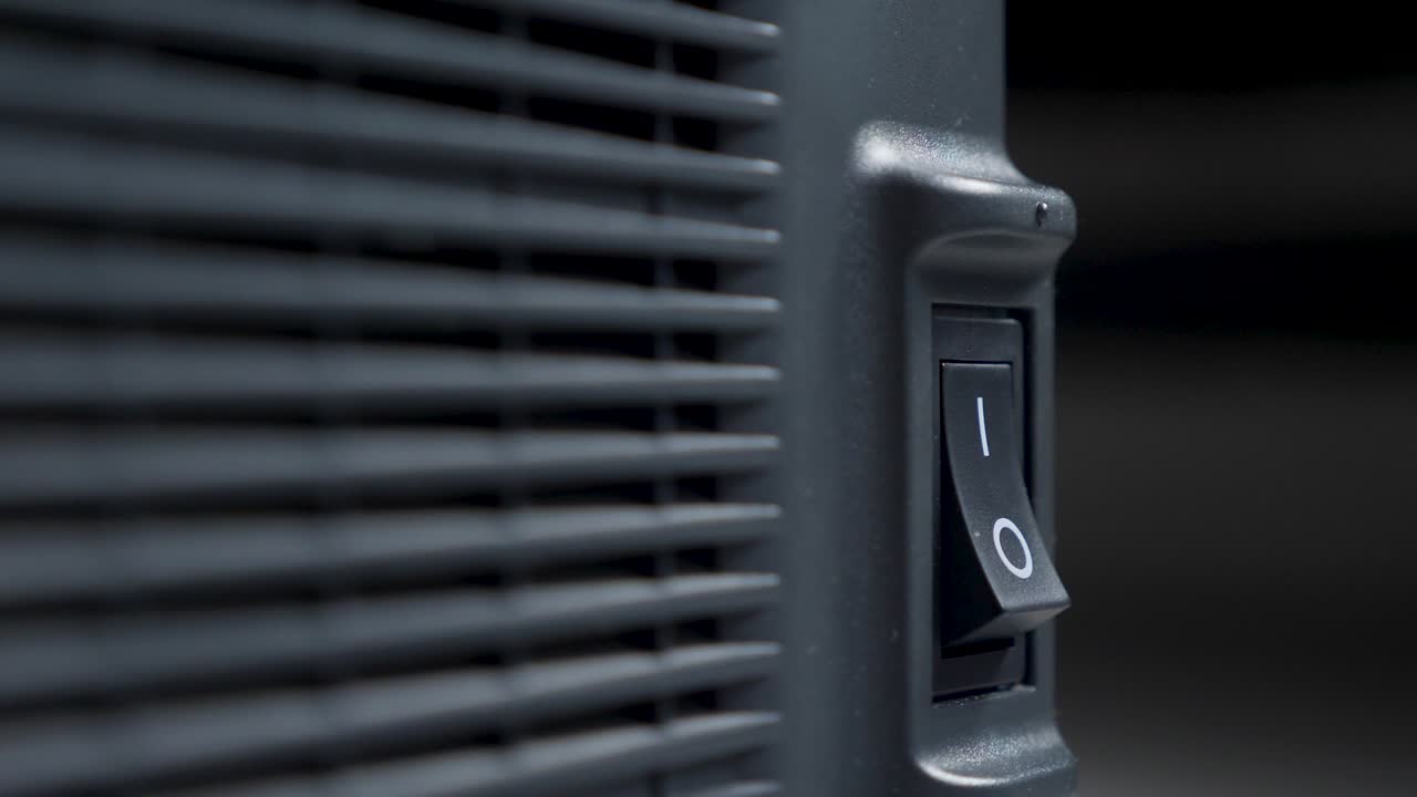 el dedo de una persona presiona se enciende y se apaga en un botón de plástico negro