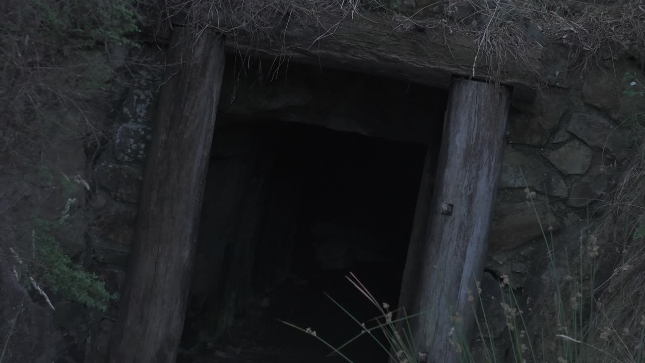 Explore a entrada misteriosa de um túnel de mineração abandonado em Melbourne durante o crepúsculo sereno. Capturado em grande angular, esta filmagem destaca os arredores naturais.