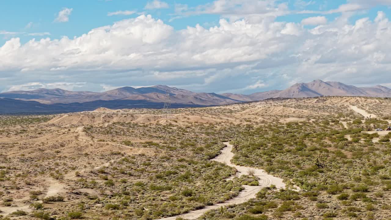 Panning drone movement showcases the canyon’s bold palette and views across the open desert plain