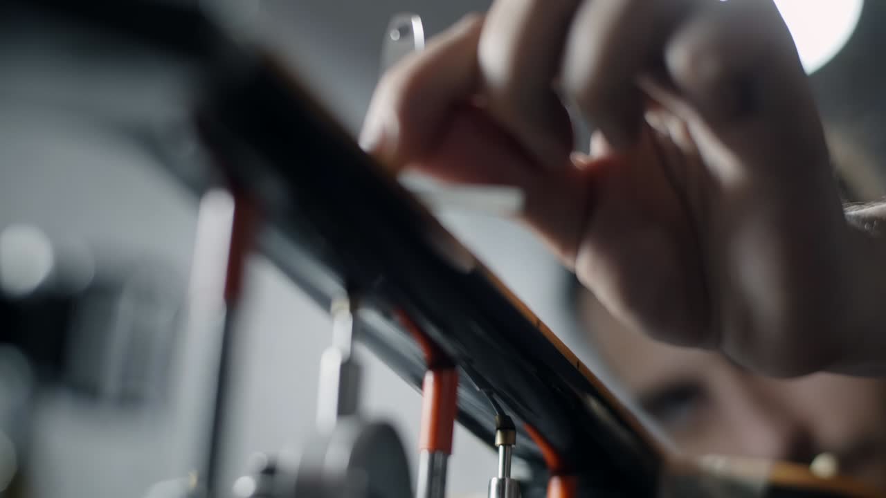Luthier checks the fretboard radius of the electric guitar after sanding, repair of the musical instruments at the guitar workshop, 4k 60p 10 bit