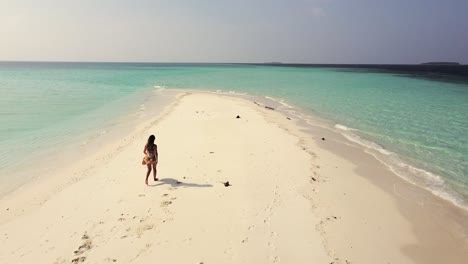 Drohnenaufnahme-Eines-Mädchens,-Das-Zum-Ende-Der-Sandbank-Geht